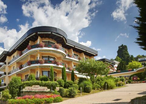 Außenansicht des mehrstöckigen Hotel Schwarzmatt mit blumengeschmückten Balkonen